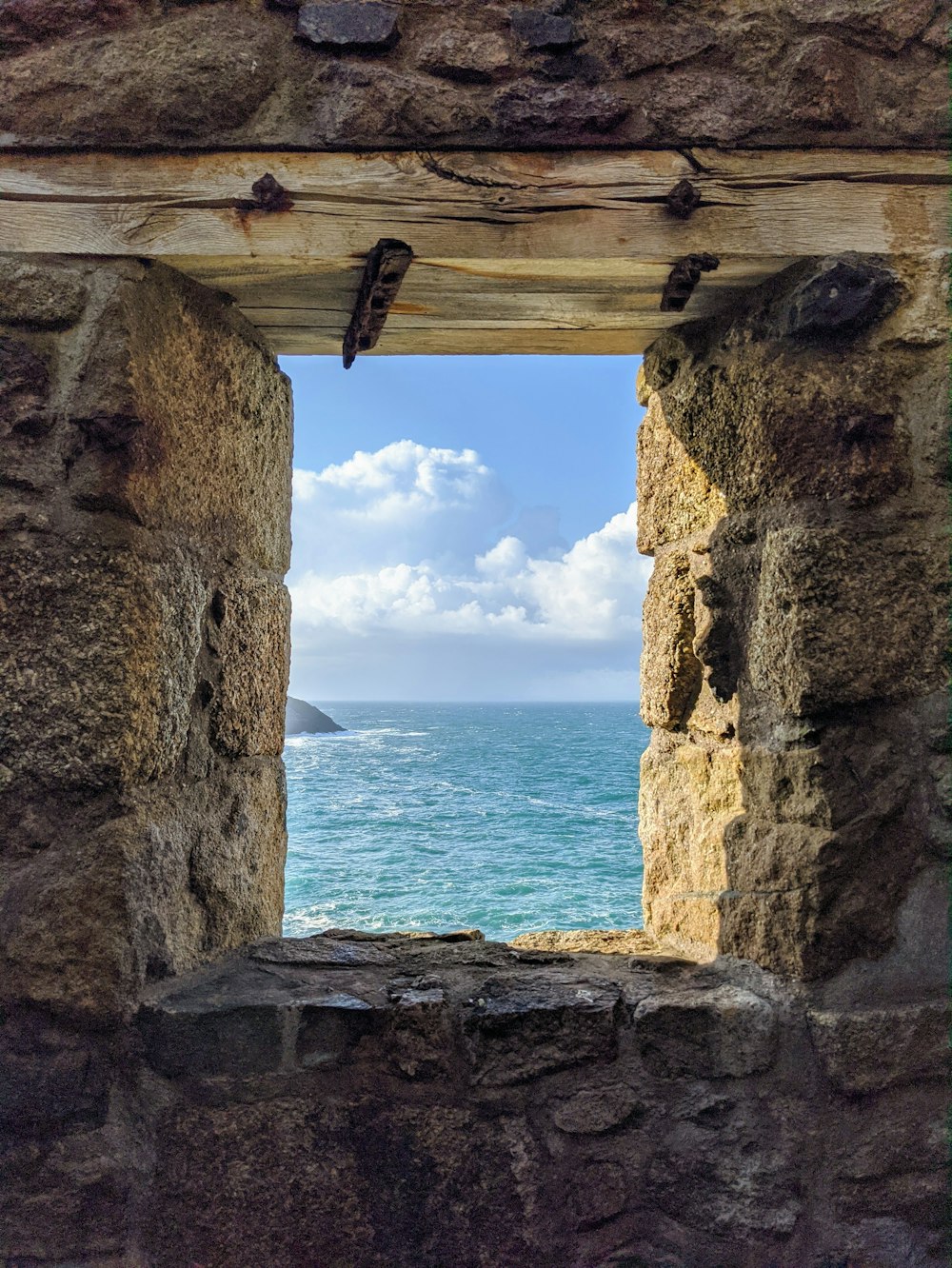 a view of the ocean from a stone building