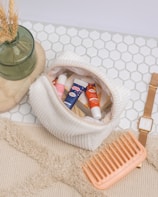a basket of toothpaste and a toothbrush on a white towel