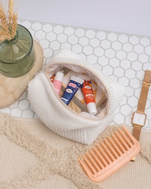 a basket of toothpaste and a toothbrush on a white towel