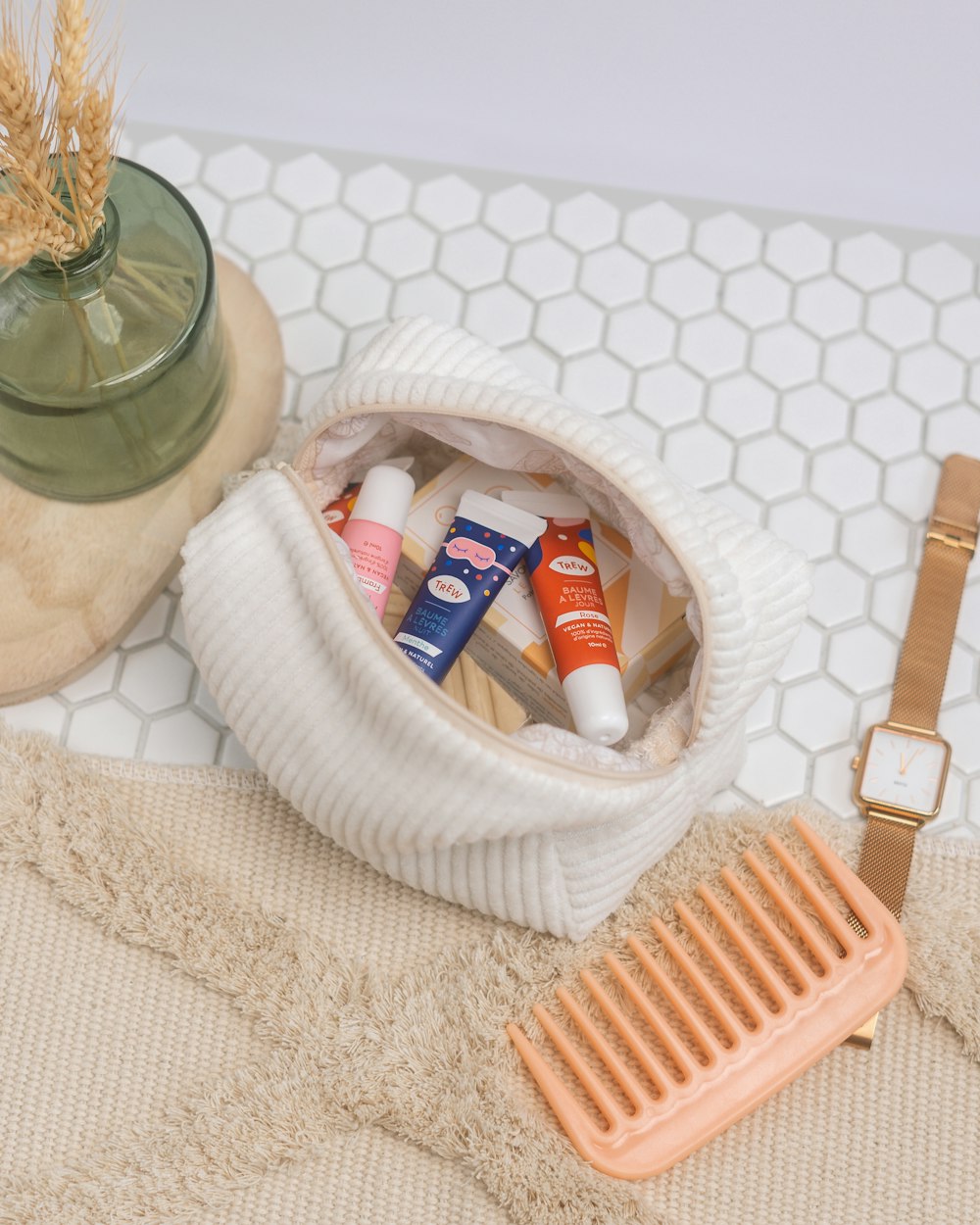 a basket of toothpaste and a toothbrush on a white towel