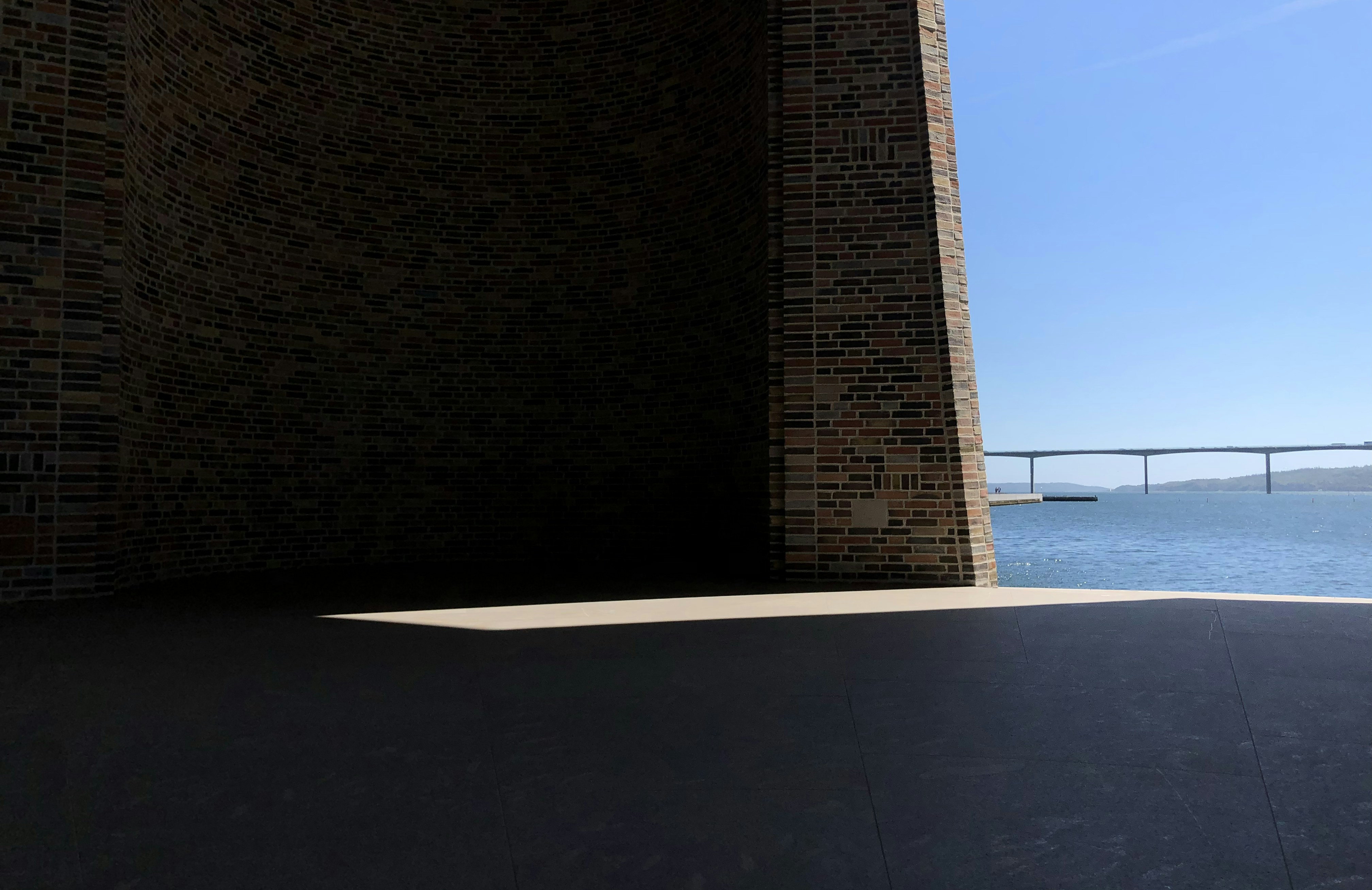 a large brick wall next to a body of water