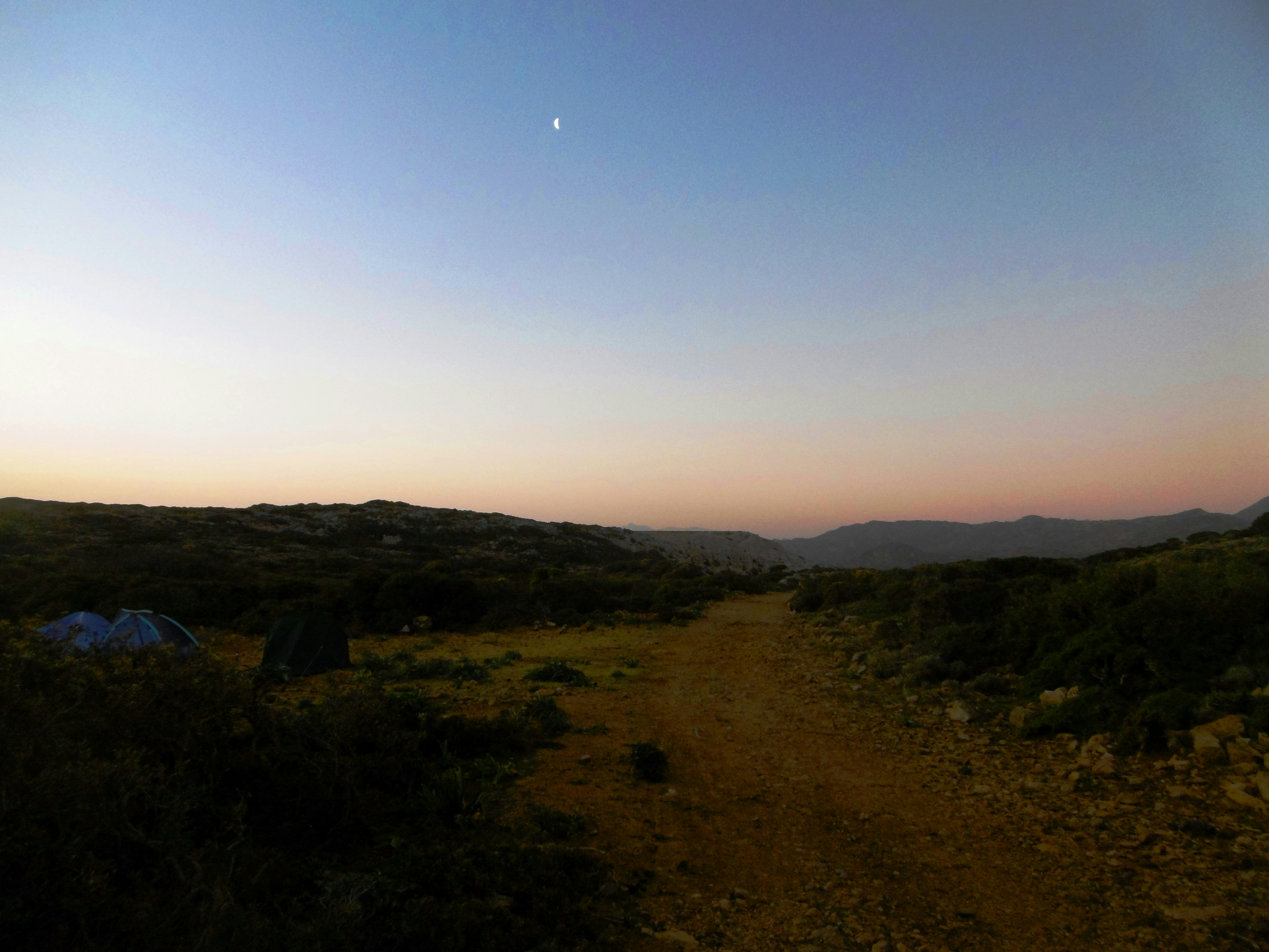 a landscape with hills and a tent