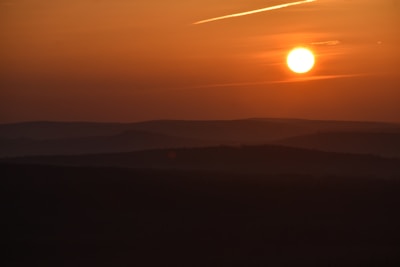 Sunset lighting casting warm tones over a large lot with rolling hills in the background