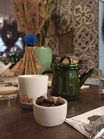 A cozy corner featuring plush cushions, a softly lit mosque silhouette in the background, and a tray of dates and sweets.