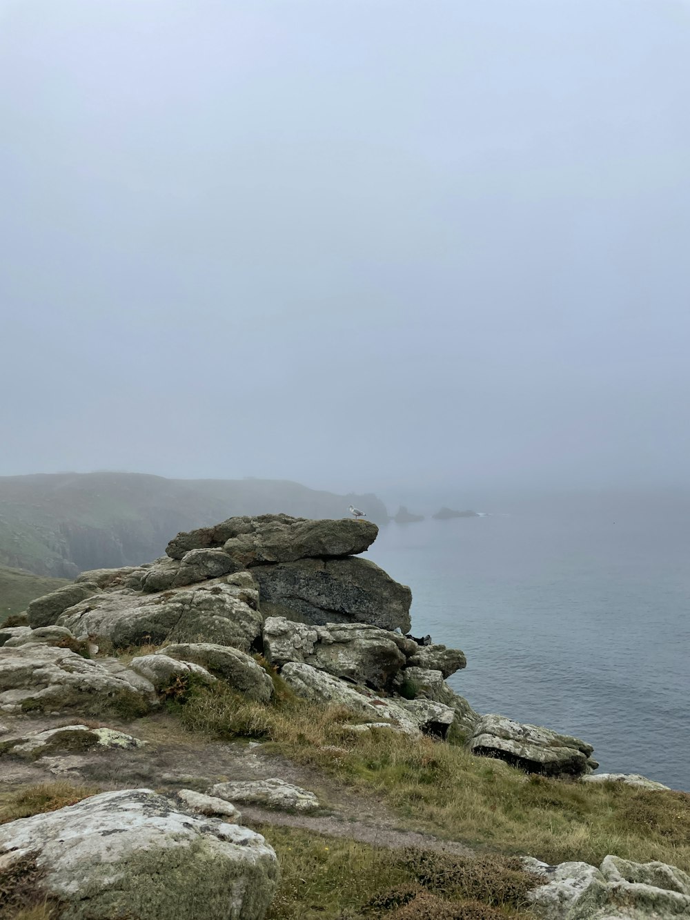 a rocky beach with a body of water in the background