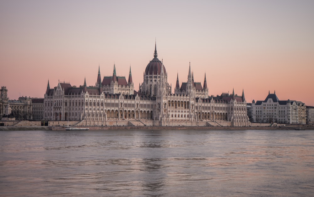 a body of water with a large building in the background with Hungarian Parliament Building in the background