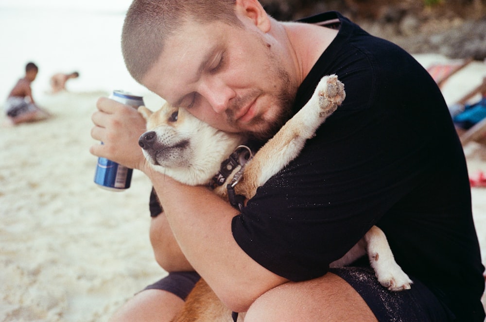 a man lying on the beach with a dog