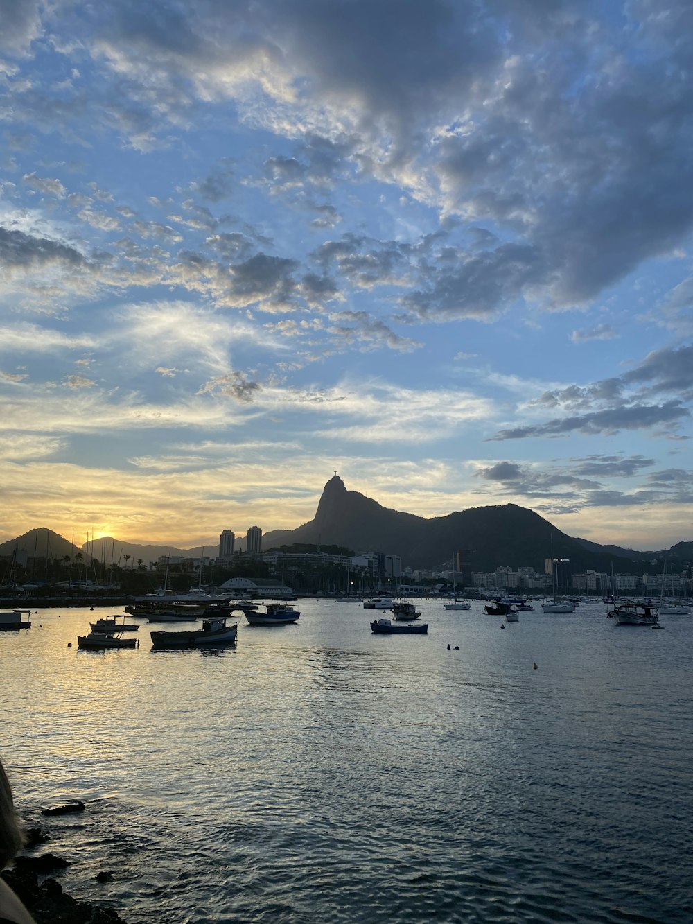 a body of water with boats in it and mountains in the background