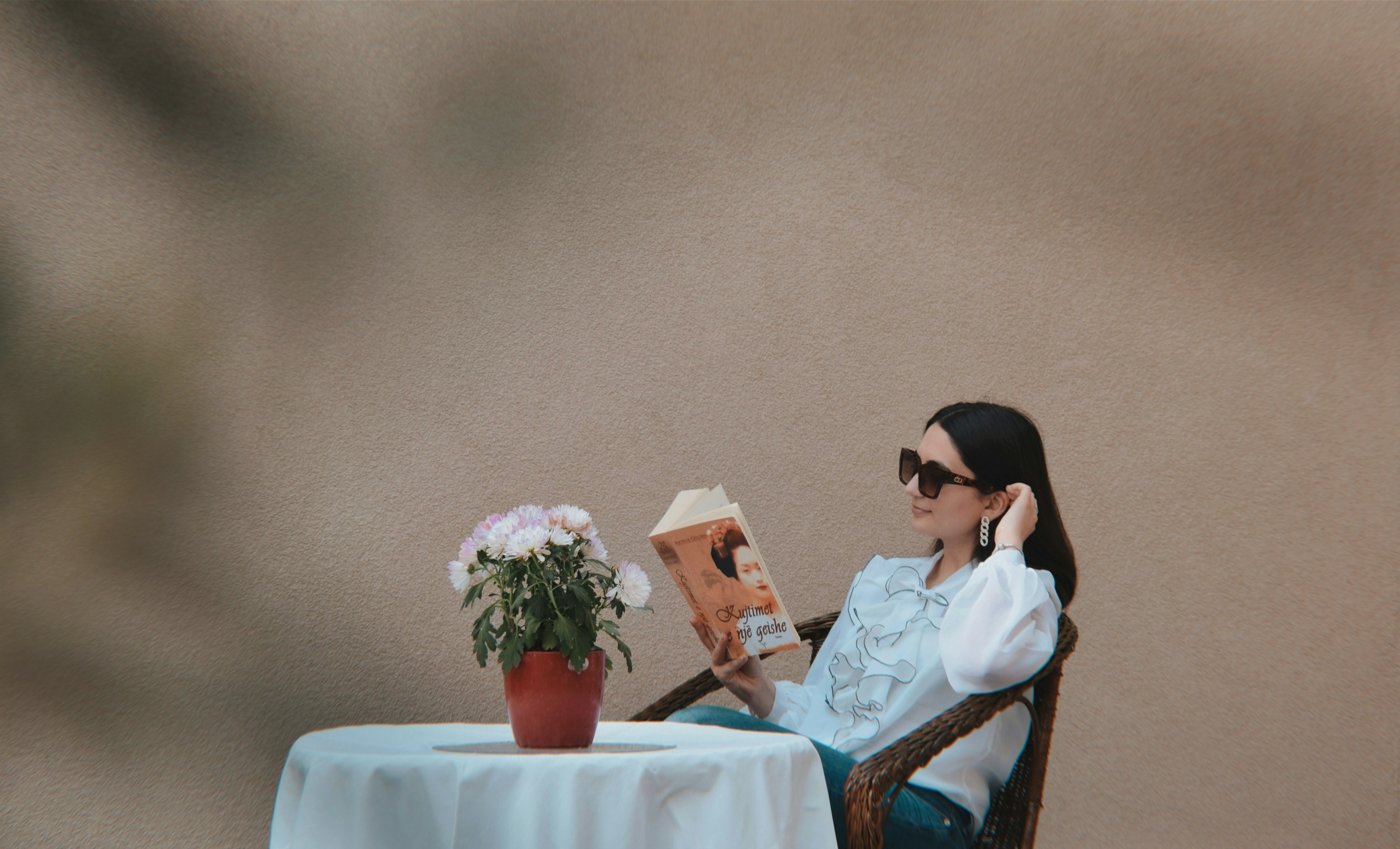 a person sitting at a table reading a book