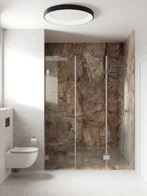 A modern walk-in shower with floor-to-ceiling glass walls and intricate marble tilework.