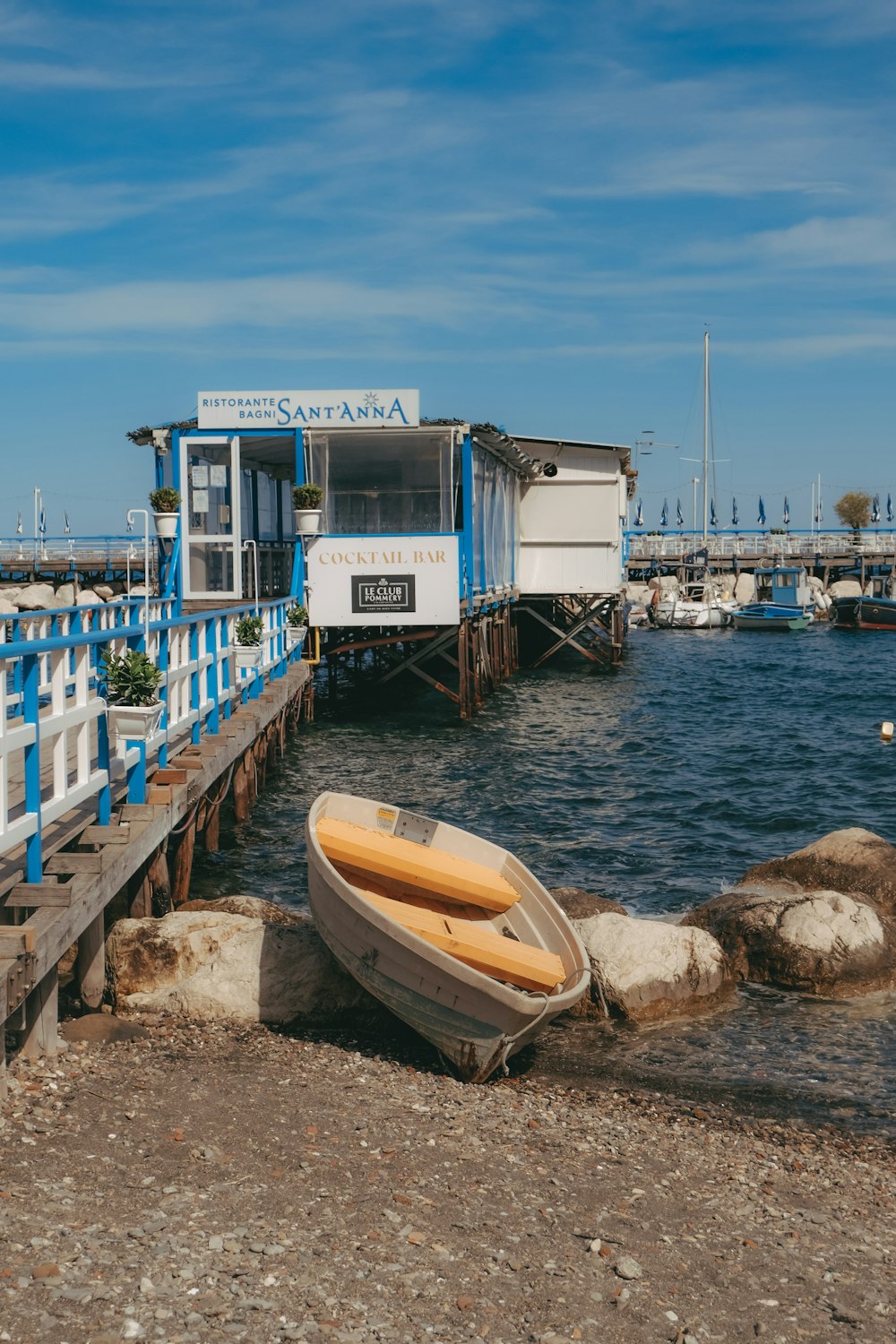 a boat sits on the shore of a lake