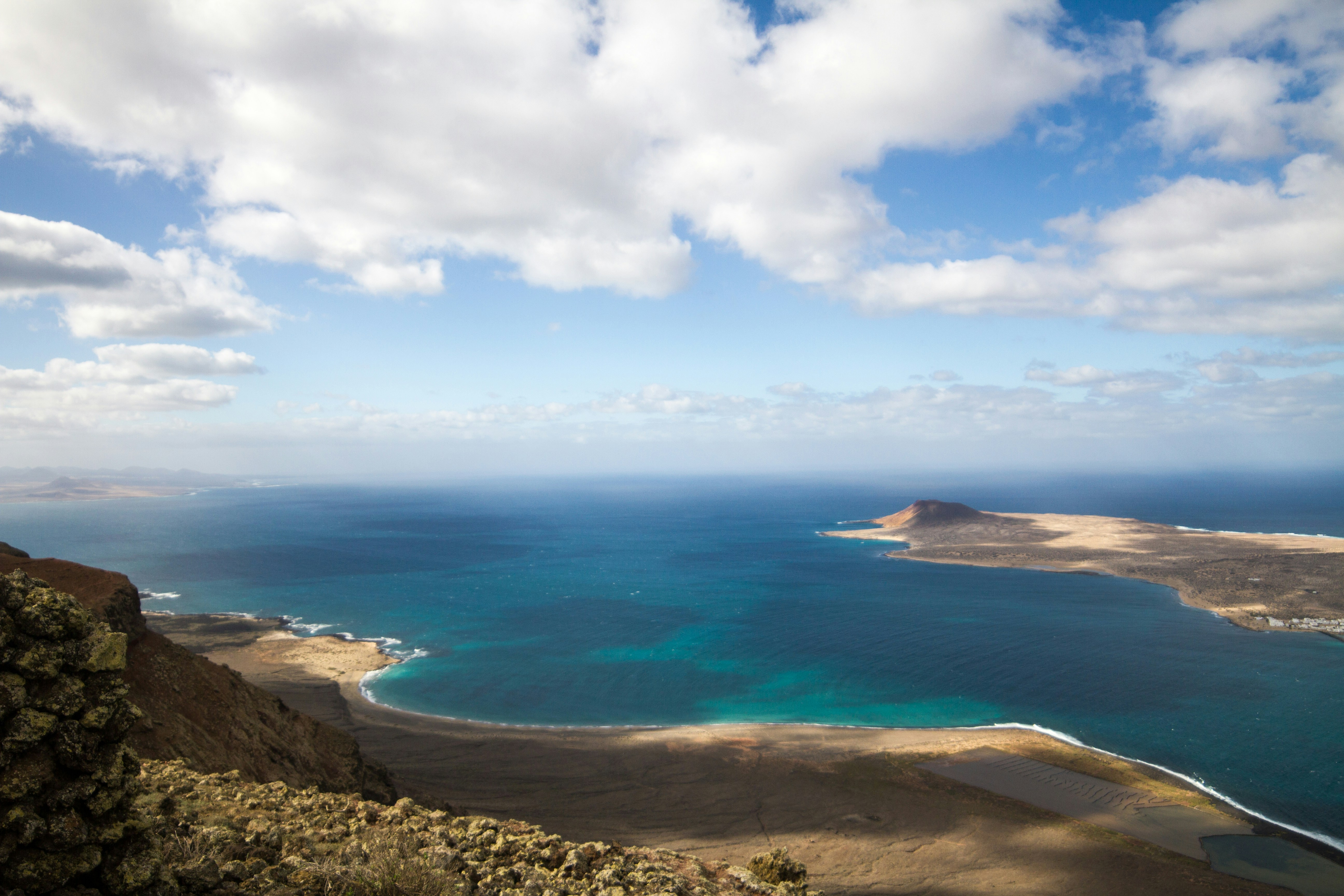 a beach with blue water - Lanzarote