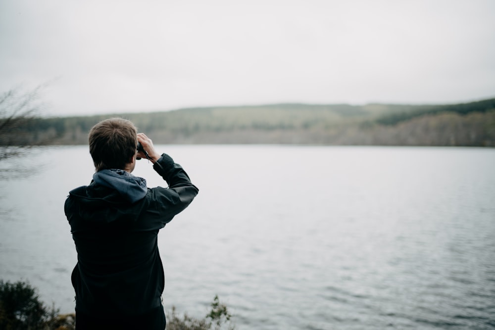 a man taking a picture of a body of water