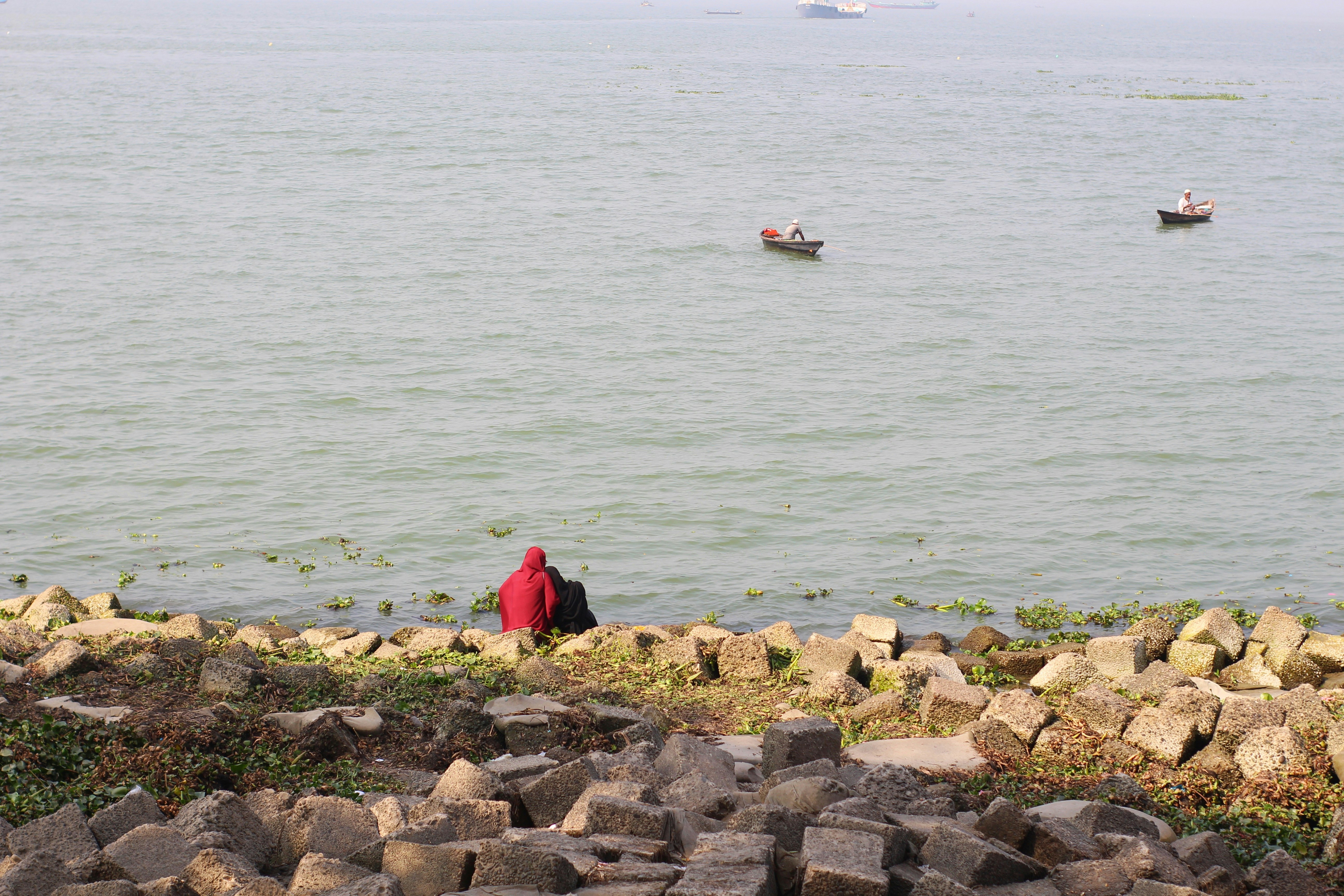 a person standing on a rock by a body of water