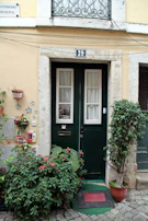 Close-up of a welcoming front door with a community notice board beside it.