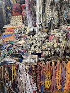 A collection of handcrafted afrocentric accessories including beaded necklaces and patterned scarves.