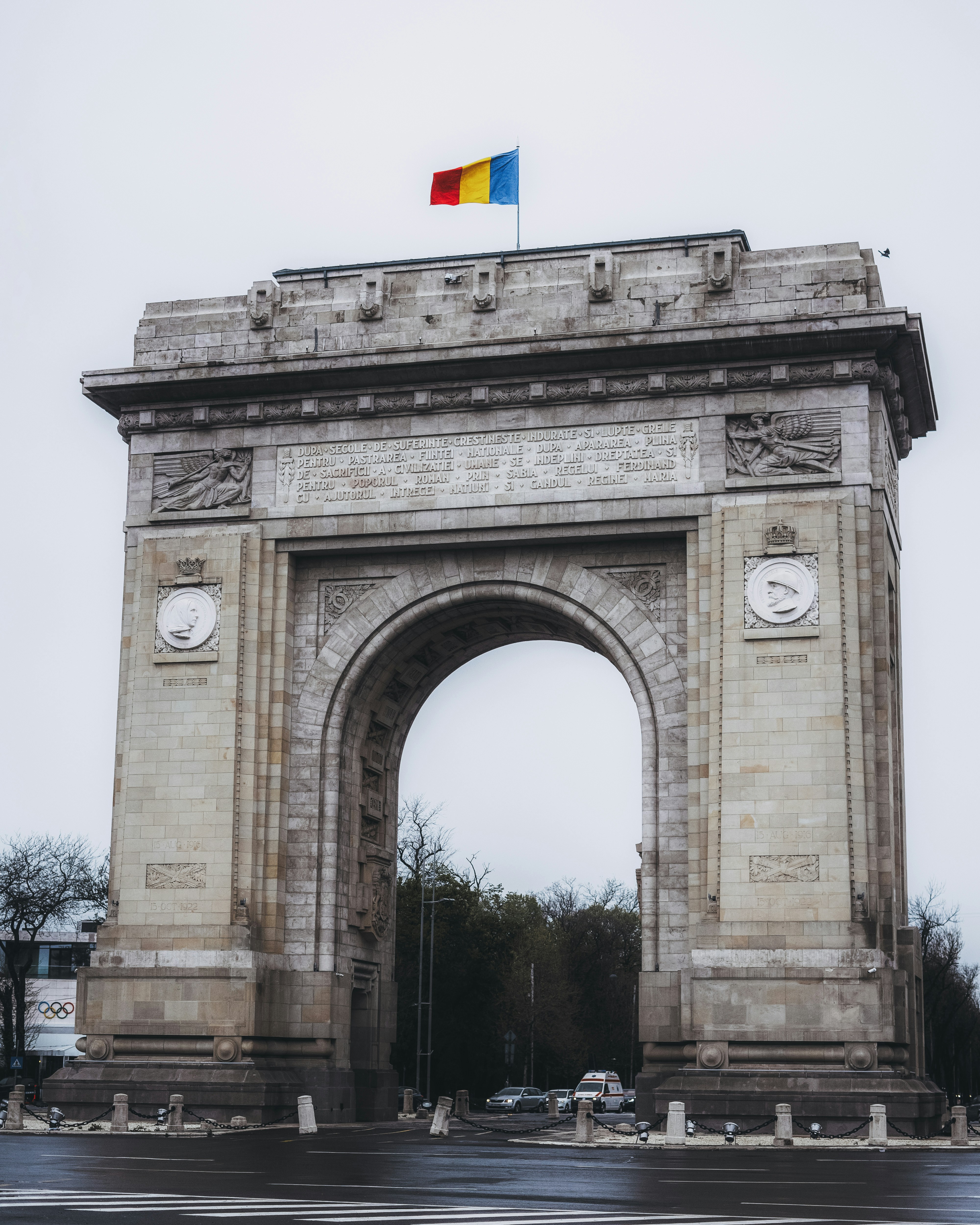 un grande arco di pietra con una bandiera in cima