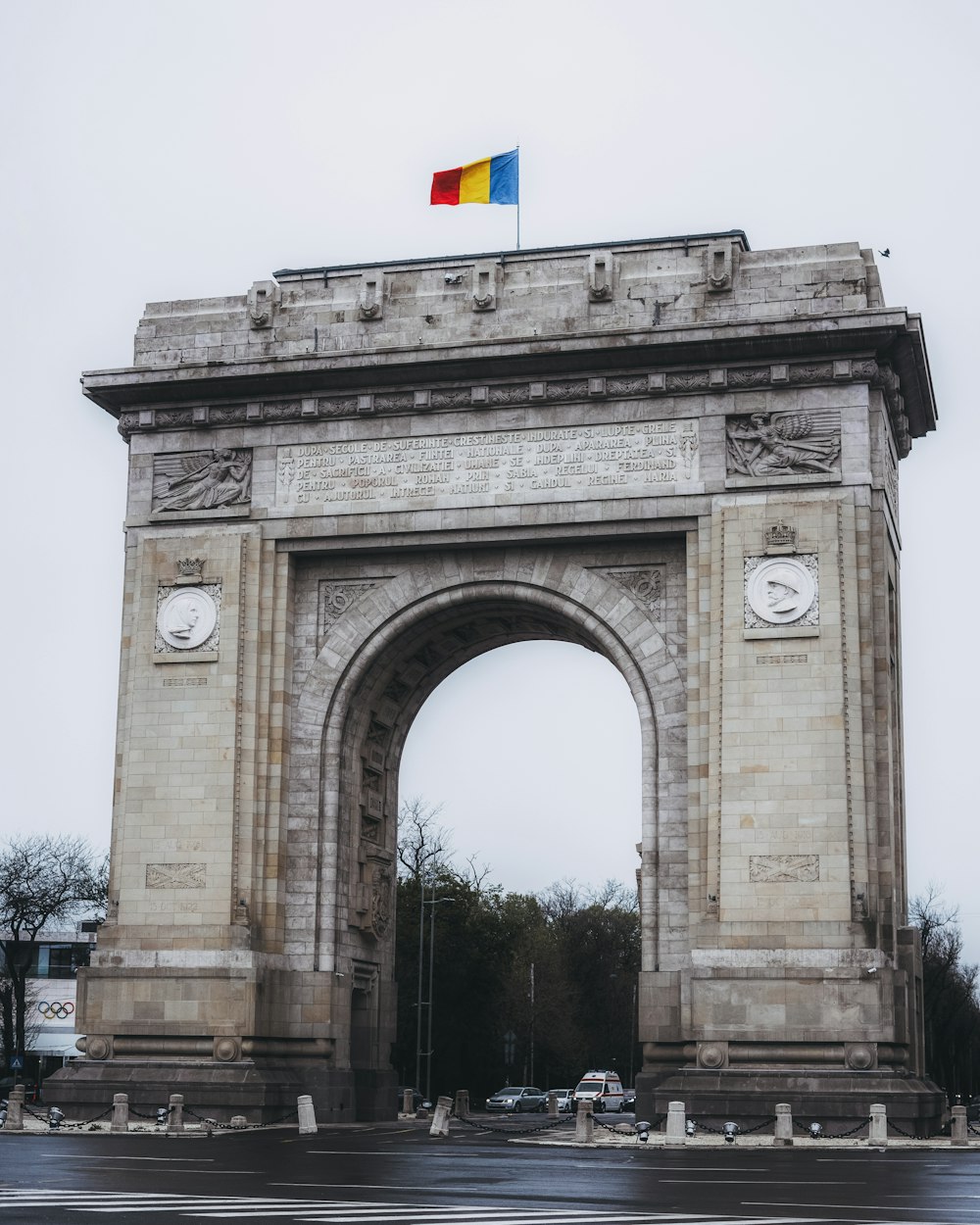 a large stone arch with a flag on top