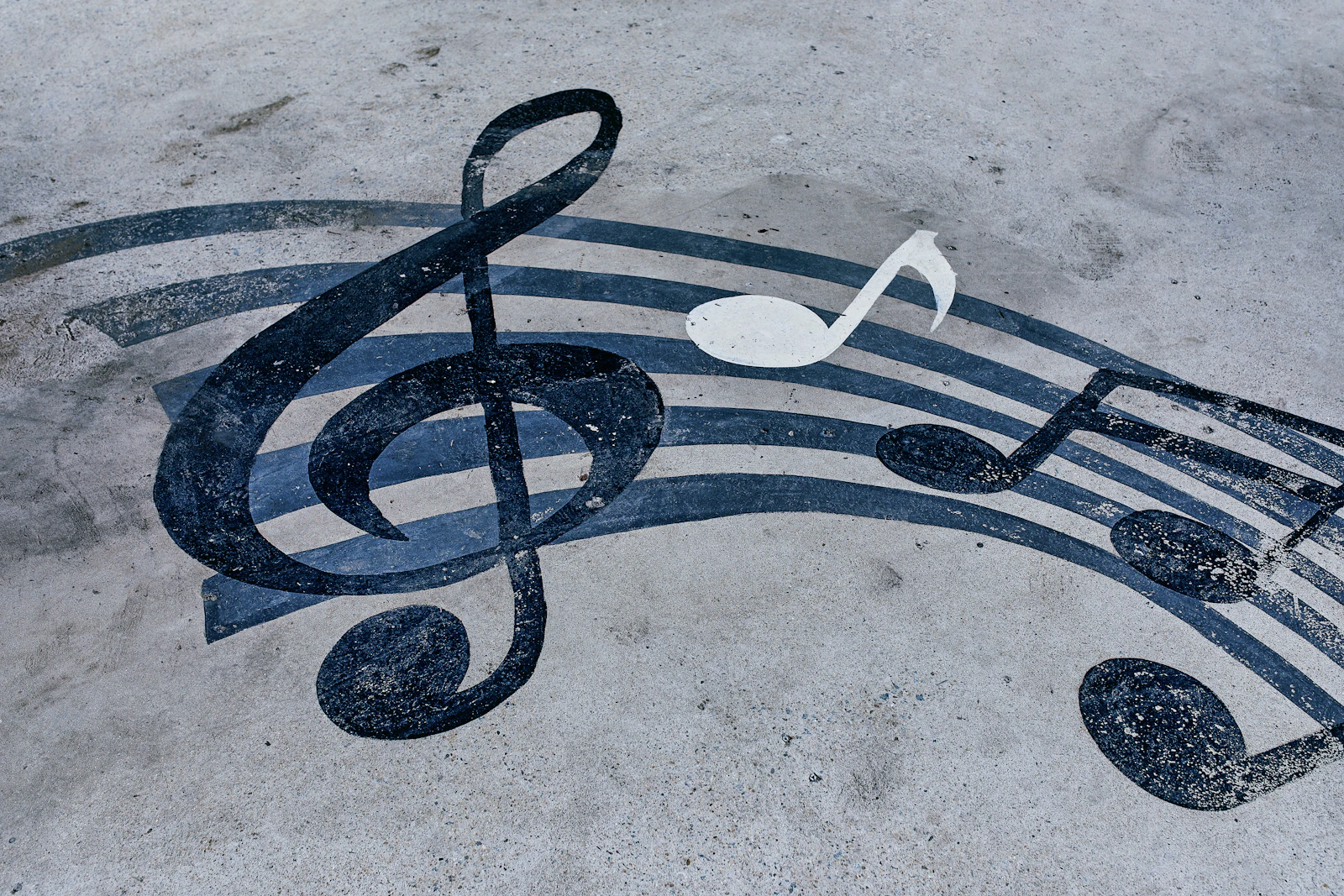 A treble clef and musical stave painted on a concrete floor