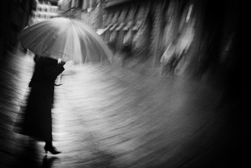 a person walks down a sidewalk with an umbrella