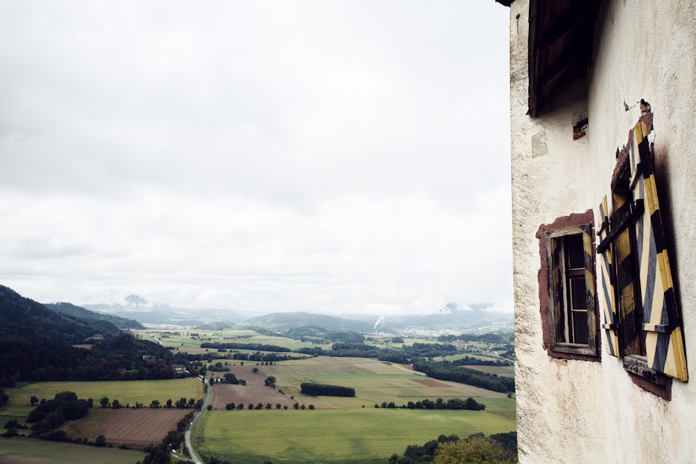 a building with a field and mountains in the background