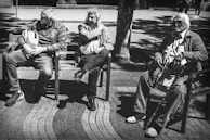 Seniors enjoying a peaceful afternoon on a shaded bench, smiling and chatting in the welcoming community space.