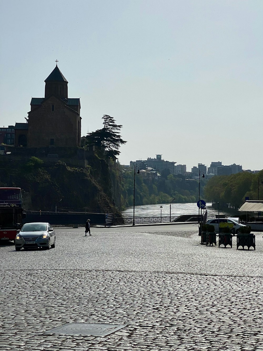 a stone road with a car and a building on the side