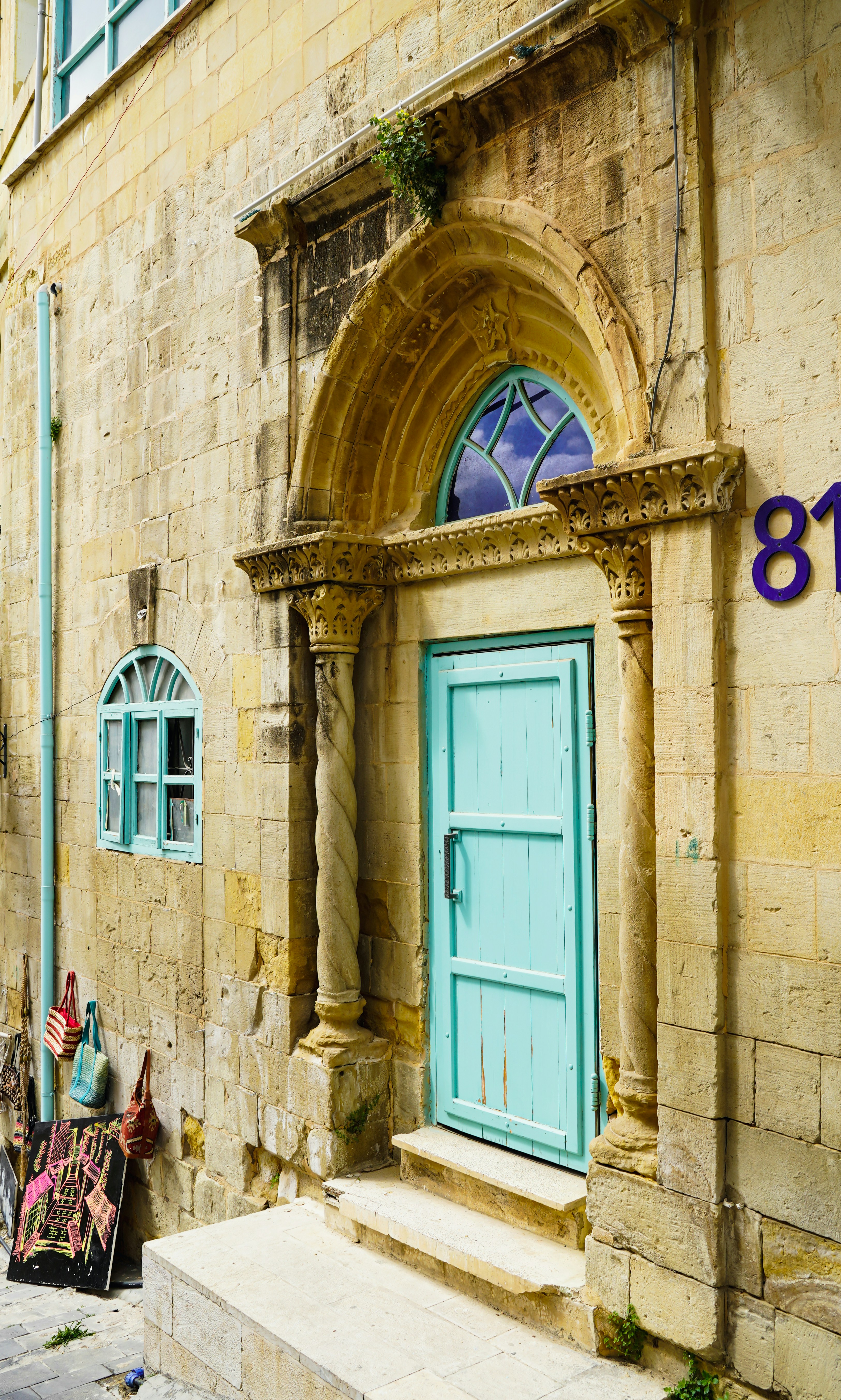 a stone building with a blue door and a statue on the front