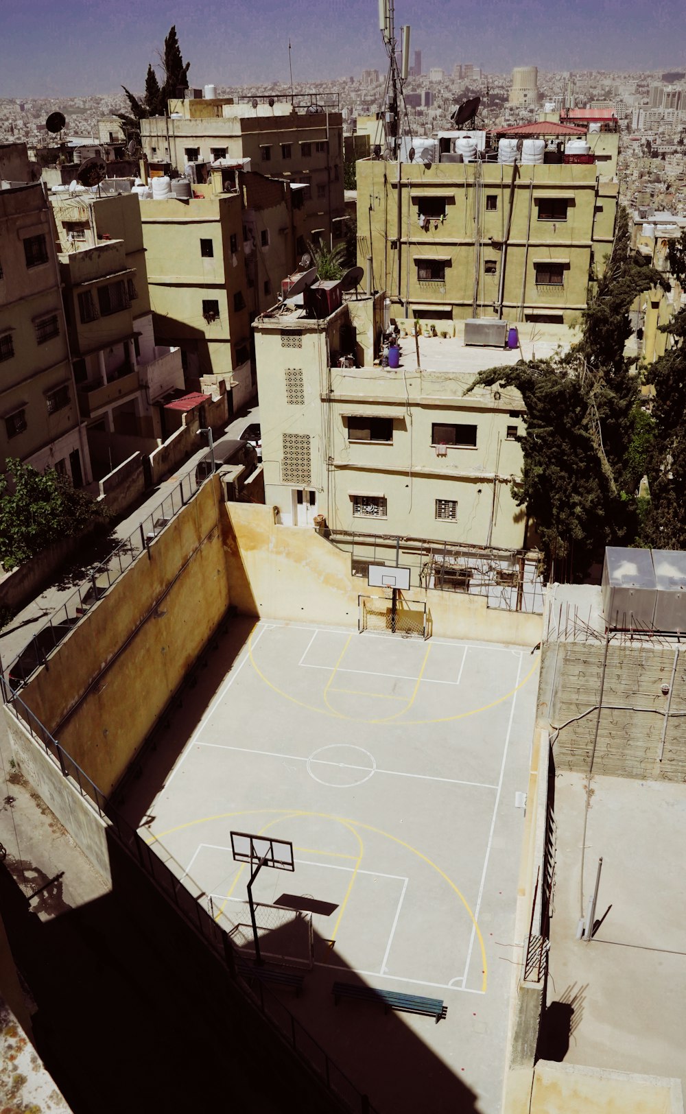 a group of buildings with a basketball court in the middle