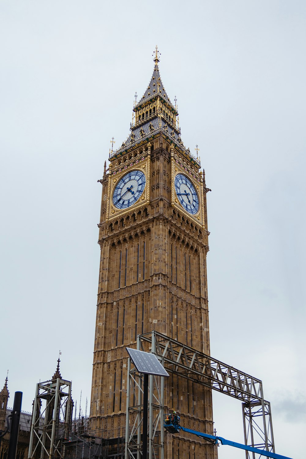 a clock tower with a weather vane with Big Ben in the background