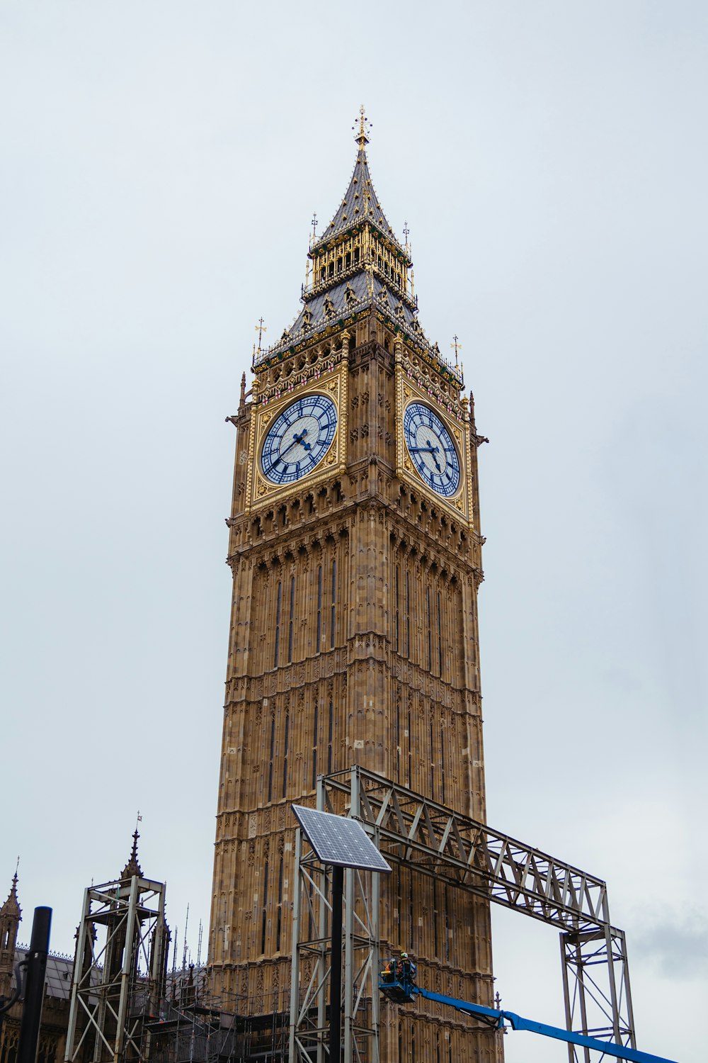 una torre del reloj con una veleta con el Big Ben al fondo