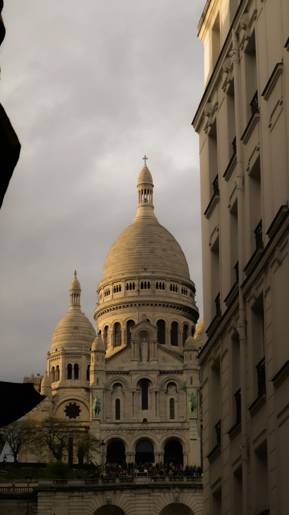 a large building with a domed roof with Sacré-Cœur, Paris in the background