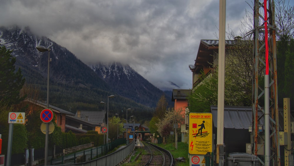a train track with buildings and mountains in the background