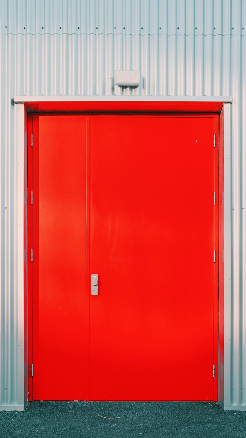 una puerta roja con una caja blanca en la parte superior