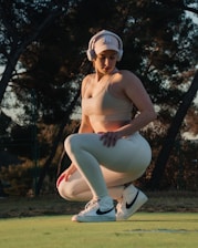 a woman wearing a helmet and squatting on a golf course