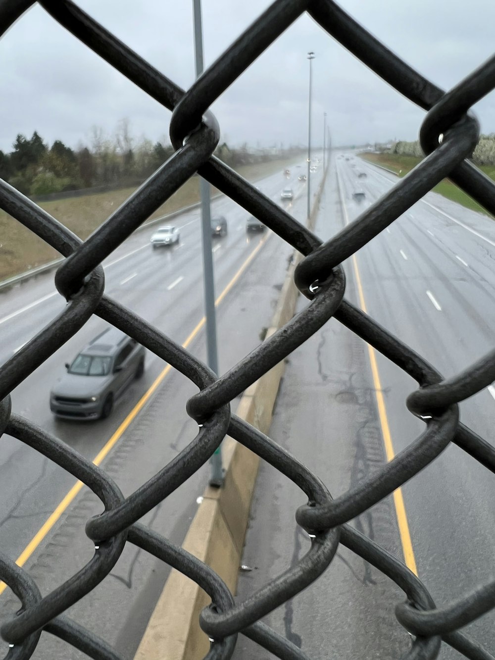 a view of a road through a fence