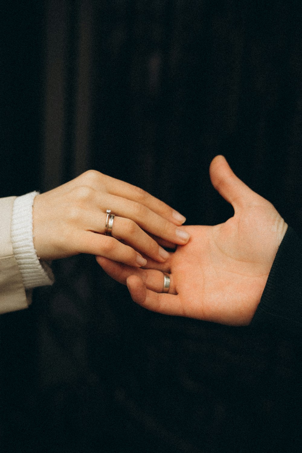a pair of hands holding a ring