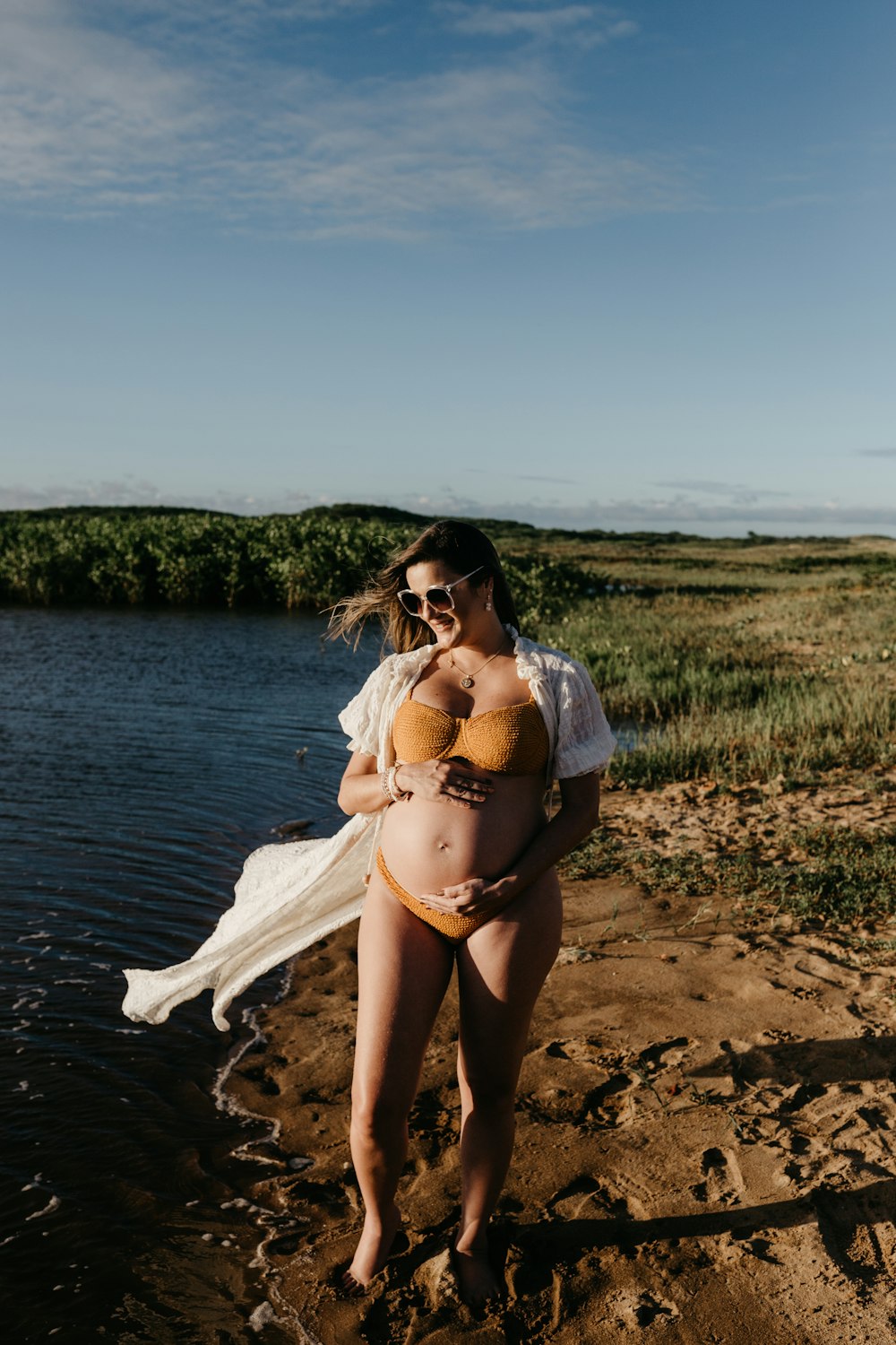 a woman in a garment standing on a beach