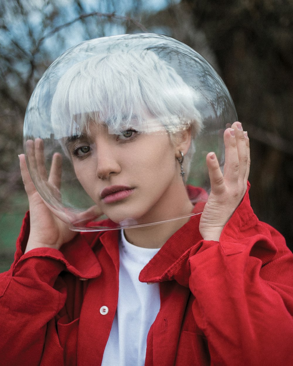 una persona con un abrigo rojo y sosteniendo un par de anteojos