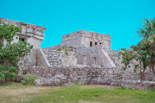 a stone building with a grass field