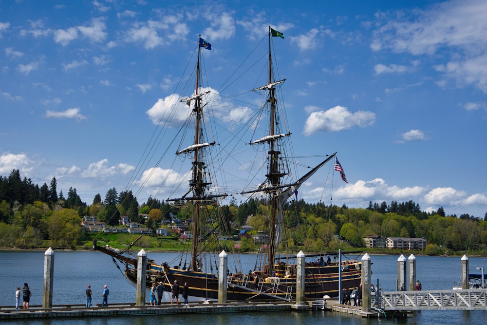 a large sailboat docked at a pier