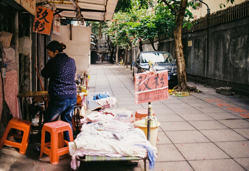 a person selling items on the sidewalk