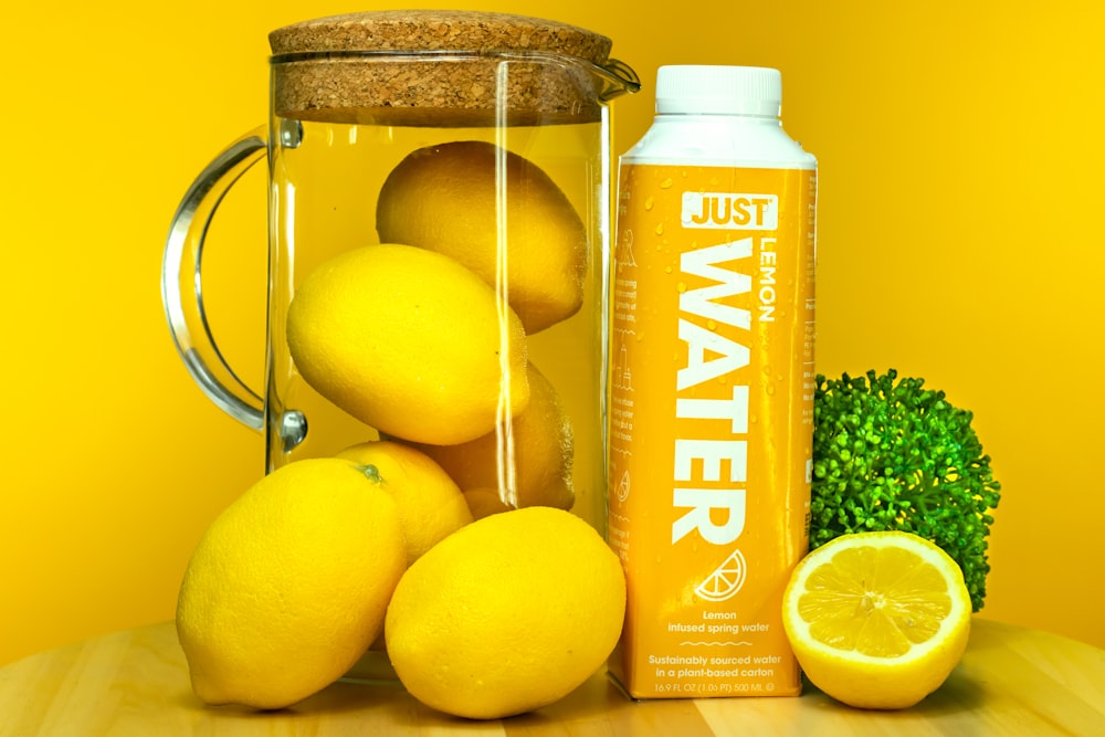 a bottle of oil next to lemons and a lemon