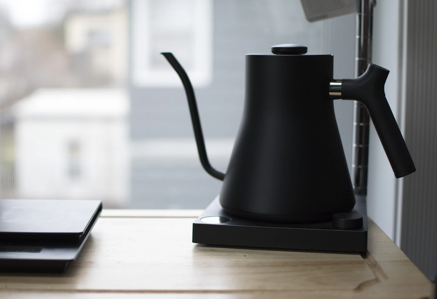 Pouring hot water from a gooseneck kettle into a pour-over coffee cup
