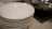A happy customer holding a set of plates from TopChoice Industries.