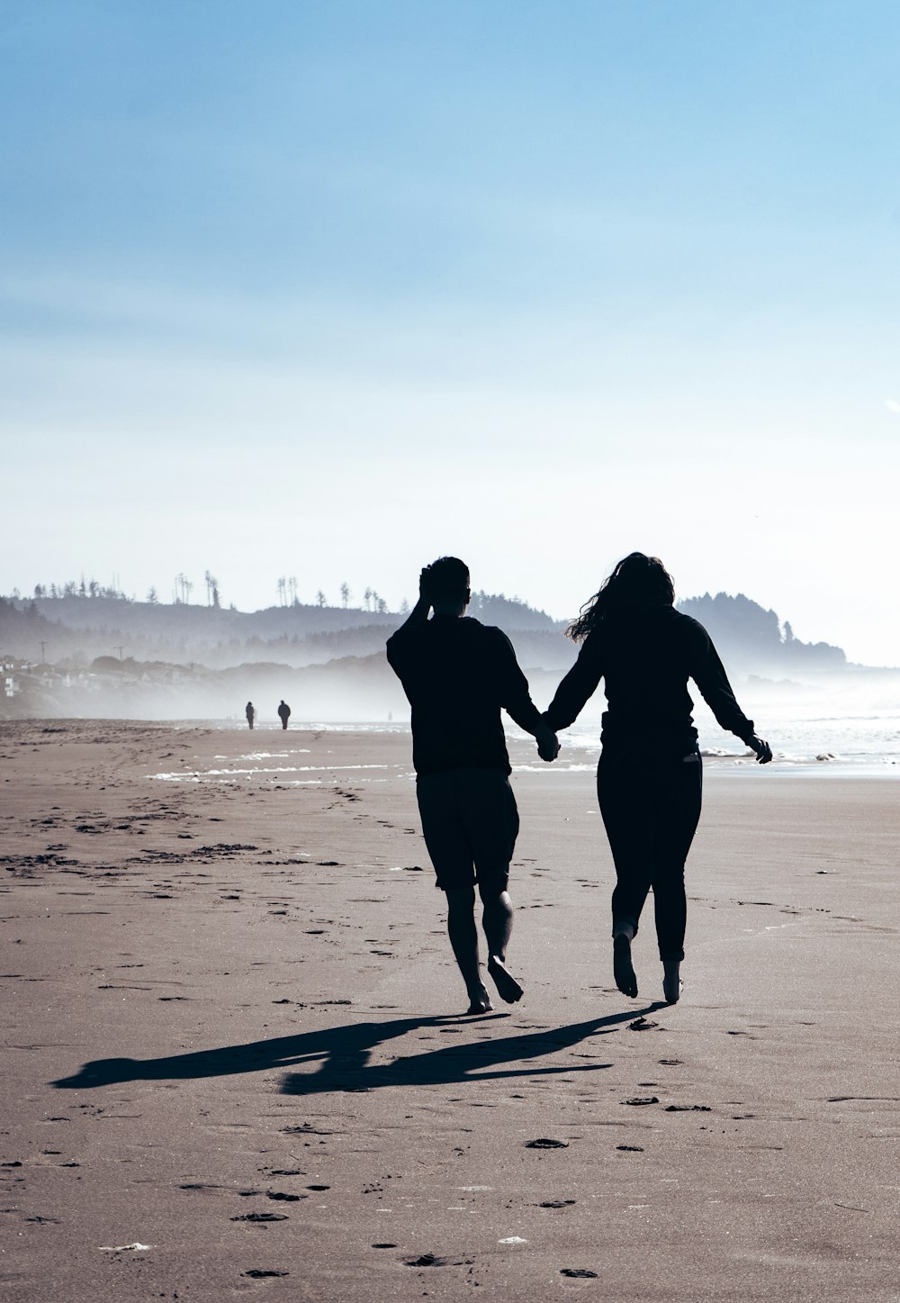 a man and woman walking on a beach