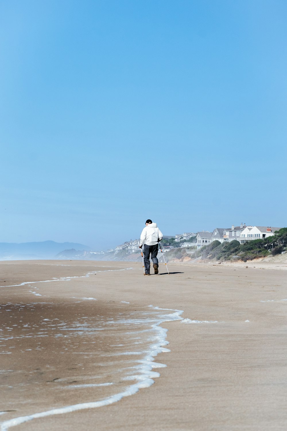 um homem que caminha em uma praia