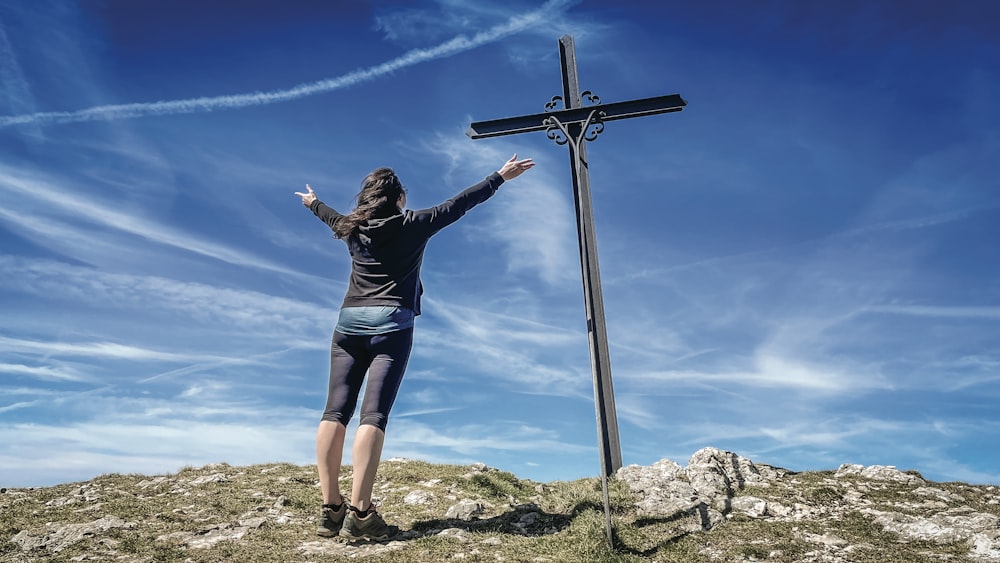 a person standing next to a cross