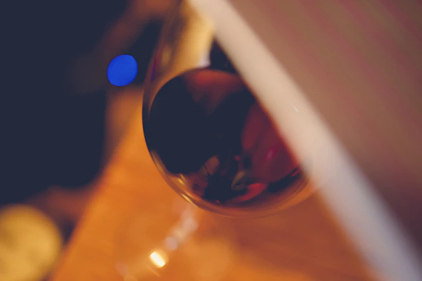 Elegant wine glasses filled with deep red Spanish wine on a dark wood table with ambient lighting