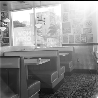 Vintage photo booth interior with warm lighting and classic black-and-white photo strips displayed.